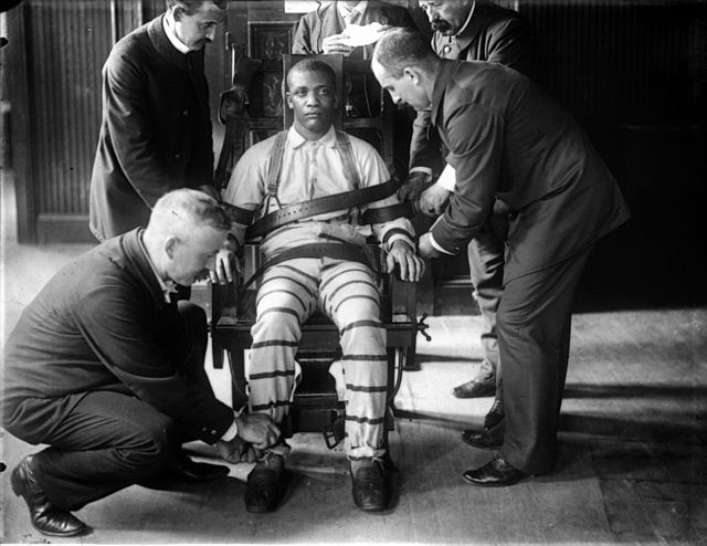 A man being strapped into the electric chair at Sing Sing prison in the early 20th century.