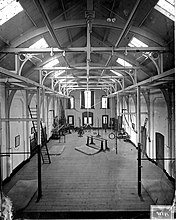 Interior of a gym in the Netherlands, around 1900 ErfgoedLeiden LEI001015553 Gymnastiekzaal van de Gymnastiekschool aan de Pieterskerkgracht in Leiden.jpeg
