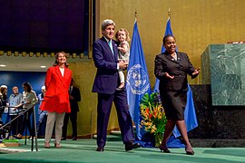 French Minister Royal Looks on as Secretary Kerry, With His Granddaughter, Walks Across the Stage to Signing the COP21 Climate Change Agreement on Earth Day in New York (26307463260).jpg