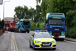 A South Yorkshire Police Audi A6 escorts Allelys Heavy Haulage trucks carrying a transformer along Manor House Street in Kingston upon Hull towards the Dogger Bank Convertor Station.