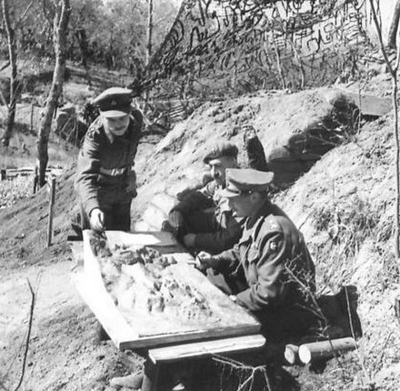 Major-General Charles Keightley (right), GOC 78th Infantry Division, at work, 2 April 1944. On a table outside his dug-out is a model of the Cassino a