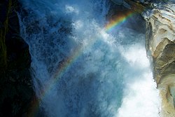 Looking down at rainbows over Sims Creeks canyon (6441602935).jpg