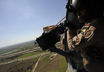 An Iraqi Army Aviation Command aerial gunner prepares to test fire his M240 machine gun, near Baghdad International Airport, 2011.