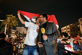 Mohsen Khazaei (right) reports on the victory of Bashar al-Assad in 2014 elections.jpg