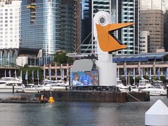 A barge decorated to look like a pelican carrying a jumbotron display.