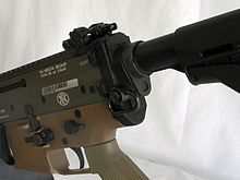 An FN SCAR L with a black push-button QD sling swivel near the butt of the riflestock. Reyes Mk II.jpg