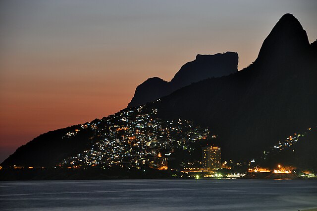 The lights of Vidigal favela in Rio de Janeiro as seen from Ipanema and Leblon beaches. The cone spire to the far right is part of the Morro Dois Irmã