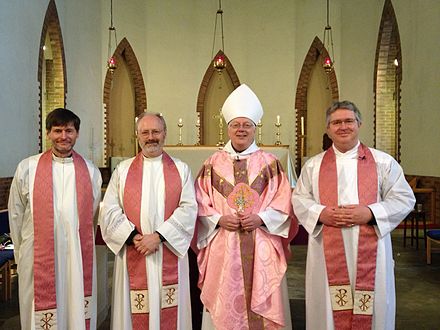 The Anglican Bishop of Willesden (London), wearing rose-pink vestments on Laetare Sunday, accompanied by three of his priests, also in rose-pink stoles, at North Acton parish church
