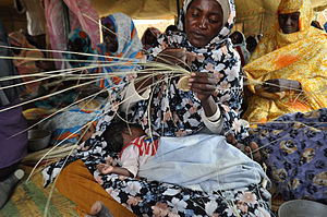 Eine Gruppe vom Krieg im Sudan vertriebener Frauen beim Korbflechten