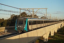 A Sydney Metro Northwest train crosses a viaduct in Kellyville. Sydney Metro Kellyville Sunset1.jpg