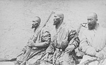 Foto van drie bebaarde, gewapende mannen