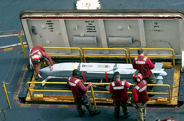 AGM-154 being brought to the flight deck of an aircraft carrier