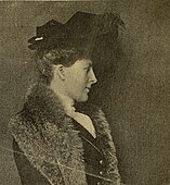 Alice Duer Miller vestita elegantemente con una pelliccia e un cappello nero.