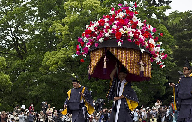 Man carrying a hollyhock float