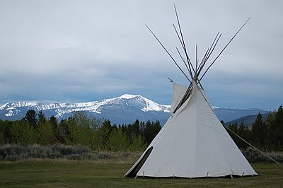 White teepee with mountains in background