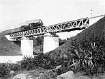 A Dutch East Indian Railway Company steam train crosses a railway bridge over the Code River (pronounced: [tʃo:ɖe]) in Yogyakarta on the line between Semarang and the "Vorstenlanden" (the Sultanate of Jogjakarta), Central Java