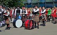 Drummers and bagpipers of the International Celtic Pipes and Drums and the members of the International Celtic Dance Team (girls in green and red costumes). (2019).