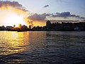 Sunset over harbor with large ships.