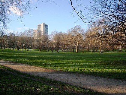 A Green Park a Buckingham-palota felől, háttérben a Hilton szálloda