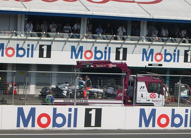 Kimi Räikkönen's broken McLaren is brought back to the pits after the race