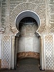 Mihrab of the prayer hall with carved stucco decoration, including darj wa ktaf motifs and an Arabic inscription in kufic script