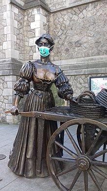 Molly Malone wearing a smiley mask during the COVID-19 pandemic Molly Malone with COVID-19 mask.jpg