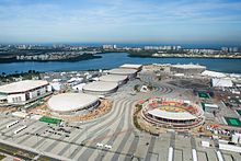 Общий вид на объекты Олимпийского парка. Справа — теннисный центр, за ним вдали — водный стадион. В центре пять зданий в ряд — велодром, за ним три здания комплекса «Арена Кариока» и «Арена ду Футуру». Слева — Олимпийская арена Рио