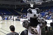 Peter pointing to a courtside camera during a mens’ basketball game in the Bren Events Center