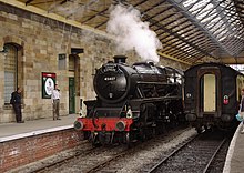 A North Yorkshire Moors Railway steam locomotive runs around a train at Pickering railway station.