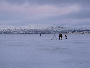 Frozen Torneträsk lake, with people walking and taking pictures on its surface (Jan 2013)