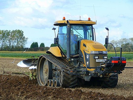 An agricultural tractor with rubber tracks, mitigating soil compaction