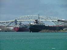 Framed by the Blue Water Bridge, two lake freighters take on cargo in Sarnia Harbour. Two Lake Freighters Loading in Sarnia.jpg