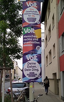 Drei Volt-Wahlplakate an einem Laternenpfahl. 1. Plakat: „Eine Gesellschaft. Gleiche Chancen für alle.“; 2. Plakat: „Menschenrechte sind unantastbar.“; 3. Plakat: „Deine Daten. Dein Ding.“