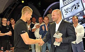 Михаил Мохнаткин (слева) на турнире «Плотформа S-70» получает награду из рук Фёдора Емельяненко. 2013 год.