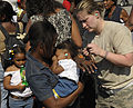 A U.S. Airman Helps Put Ear Plugs in the Ears of an Infant in Port-au-Prince, Haiti.jpg