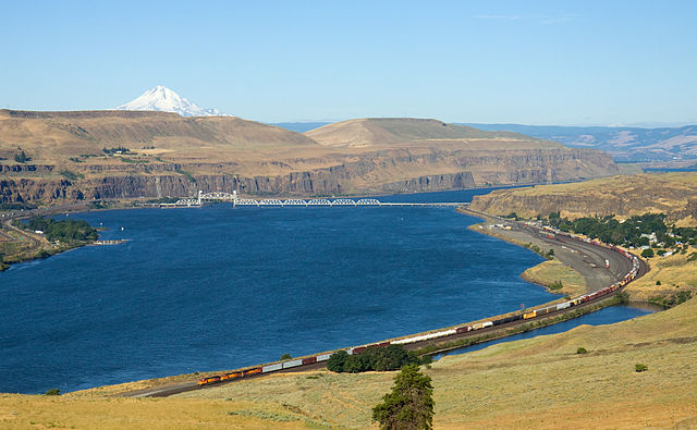 Wishram railway yard with a BNSF freight train with Oregon cliffs and Mount Hood in the background.
