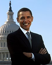 Foto di Obama sorridente con le braccia incrociate, con il Campidoglio e il cielo sullo sfondo