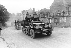 Bundesarchiv Bild 101I-055-1572-30, Frankreich, Zugmaschine mit Flak in Ortschaft.jpg