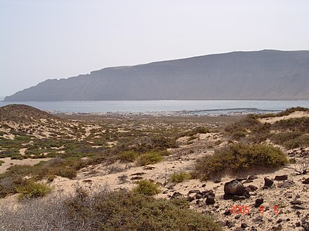 View of Caleta de Sebo from the island's inland, with hills of Lanzarote in the background