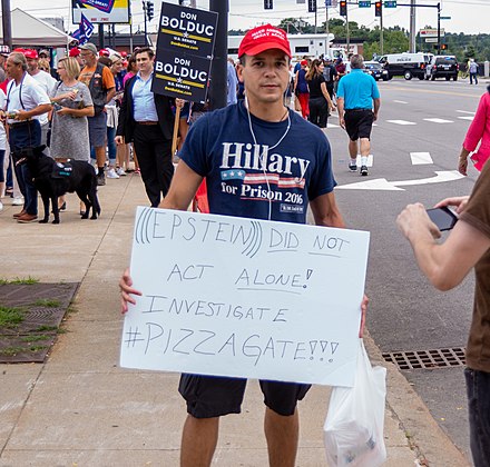 A partisan protester alleging outside involvement five days after Epstein's death, referencing the Pizzagate conspiracy theory and using triple parentheses around Epstein's name