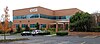 A two story orange brick building with windows and an ESI logo.