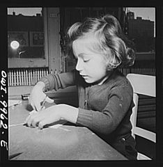 French refugee child learning to sew