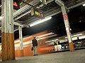 Night shot of a man standing in front of a speeding train at Haijima Station.