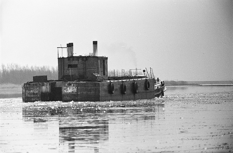 File:IJsselmeer nog dicht, een sleepbootje met een grote bak er achter begonnen de zu, Bestanddeelnr 915-9133.jpg