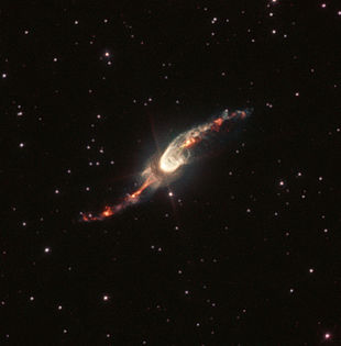 Fotografie de la telescopul spațial Hubble.  Jetul nodular, în formă de S, poate fi văzut clar în emisiunea roșiatică de Hα.