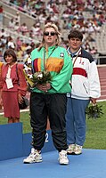 Australian athlete Jodi Willis stands at the podium after winning the Women's Shot Put B2 event at the 1992 Summer Paralympics. Jodi Willis on Barcelona 1992 Paralympics medal podium.jpg