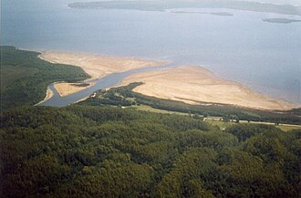 King river at entrance to Macquarie Harbour - the West Coast Wilderness Railway line passes from the right of this picture to enter the King River Valley at the left of photo. Delta of eroded material is typical at this location. Hell's Gates is at top of picture (out of view) and Strahan is to the right off photo. Photo hazy due to bushfires of January 2003. King river at macquarie harbour.jpg