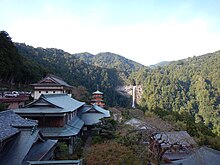 An image of Nachi Falls, part of the Kumano Nachi Taisha shrine complex, the waterfall is visible over a three-storied Buddhist pagoda.