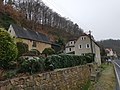 Farmhouse with barn and retaining wall facing the road