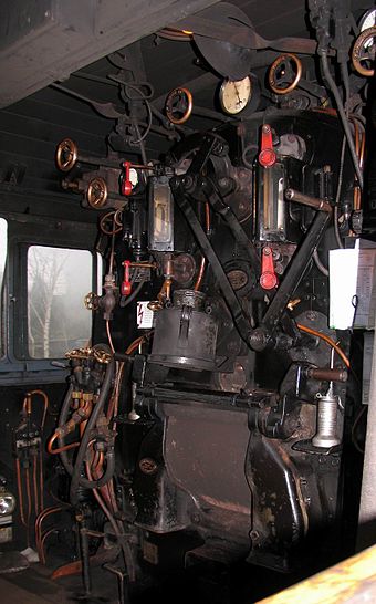 Cab of a German steam locomotive, view of the fireman's side. In the right middle of the image is clamped a driver's timetable, below which the firebox door can be seen.